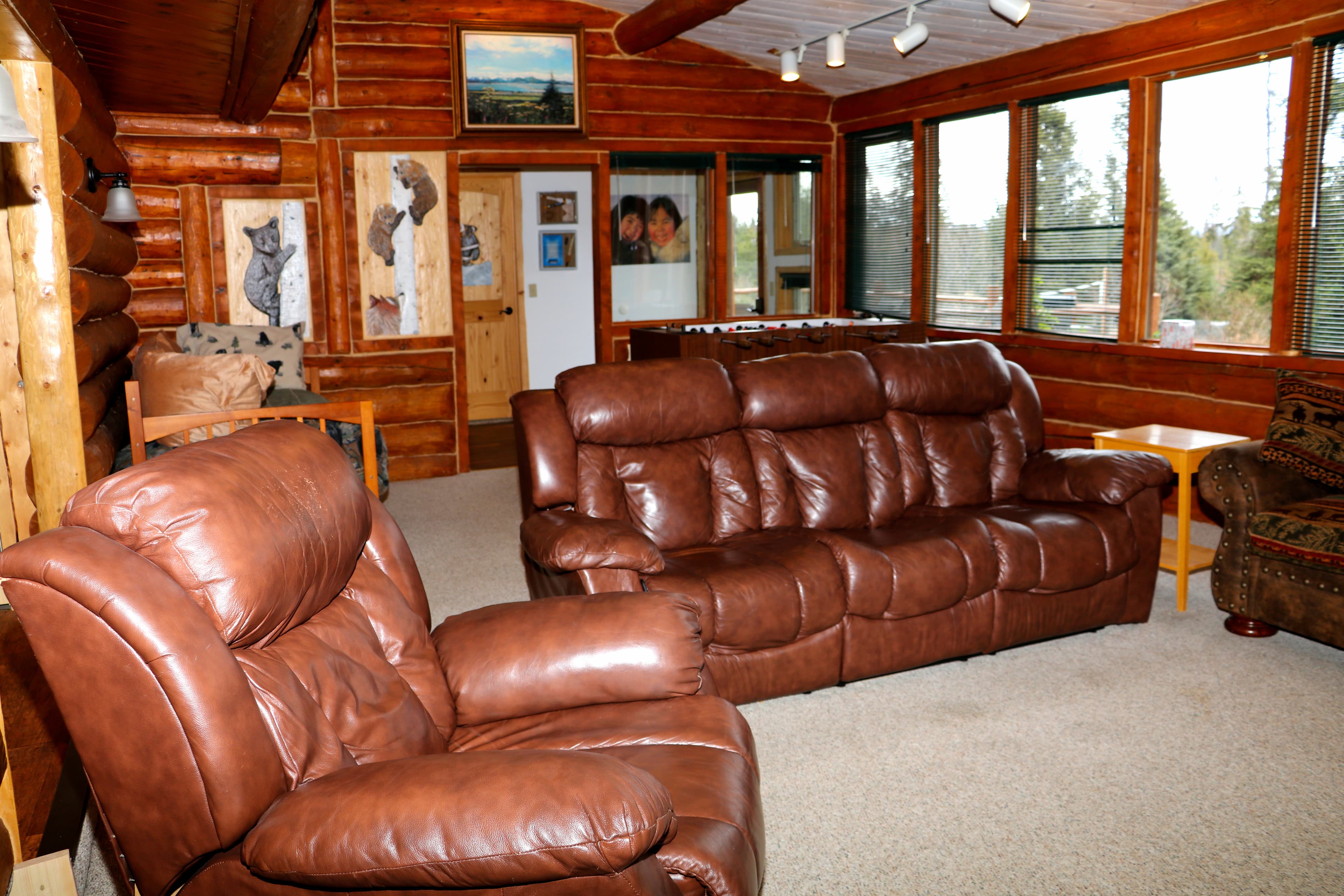 Den with rich brown leather recliner and couch.