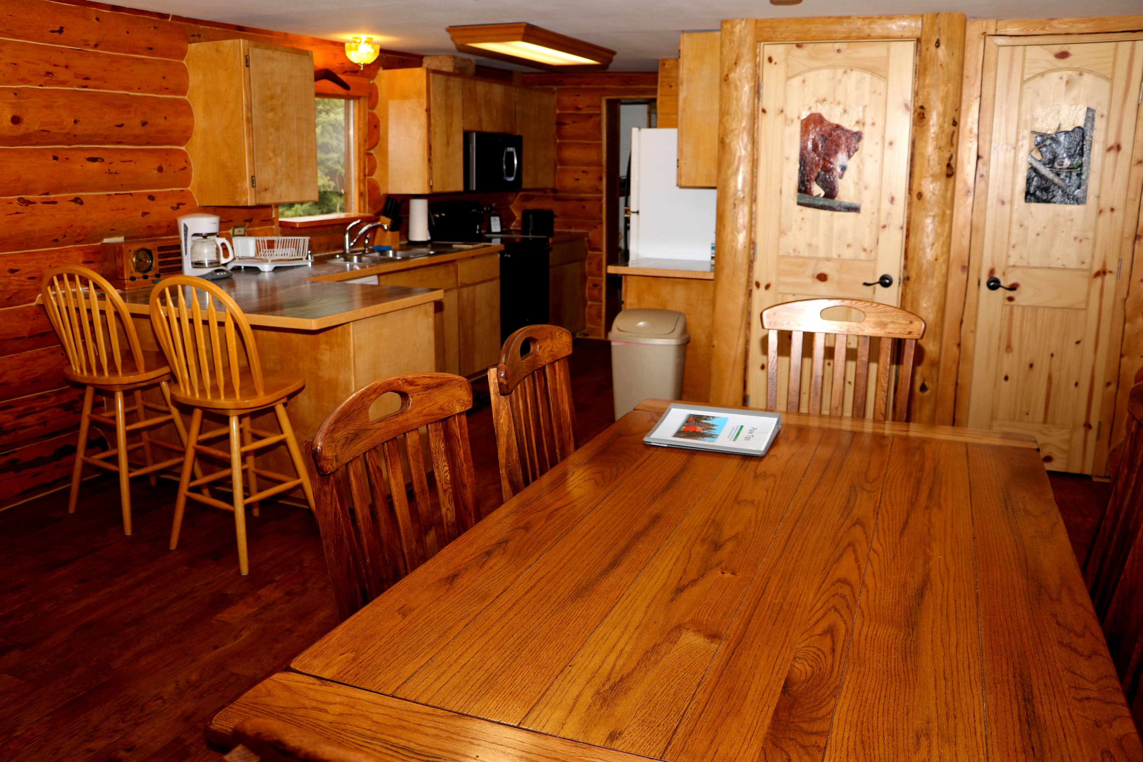 Kitchen and dining area with table and chairs.