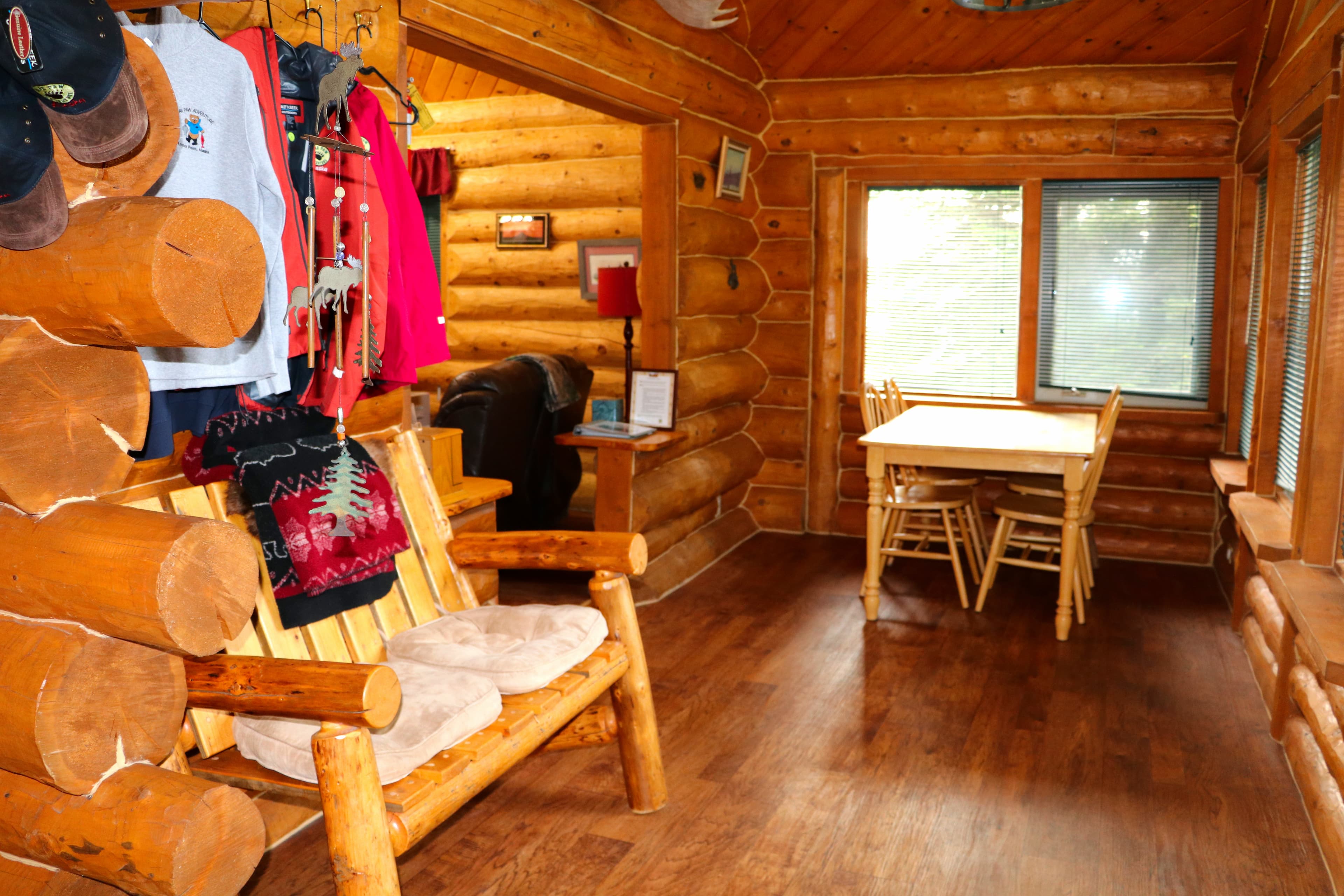 Entry area with bench, coat hooks on wall, and dining table with chairs.