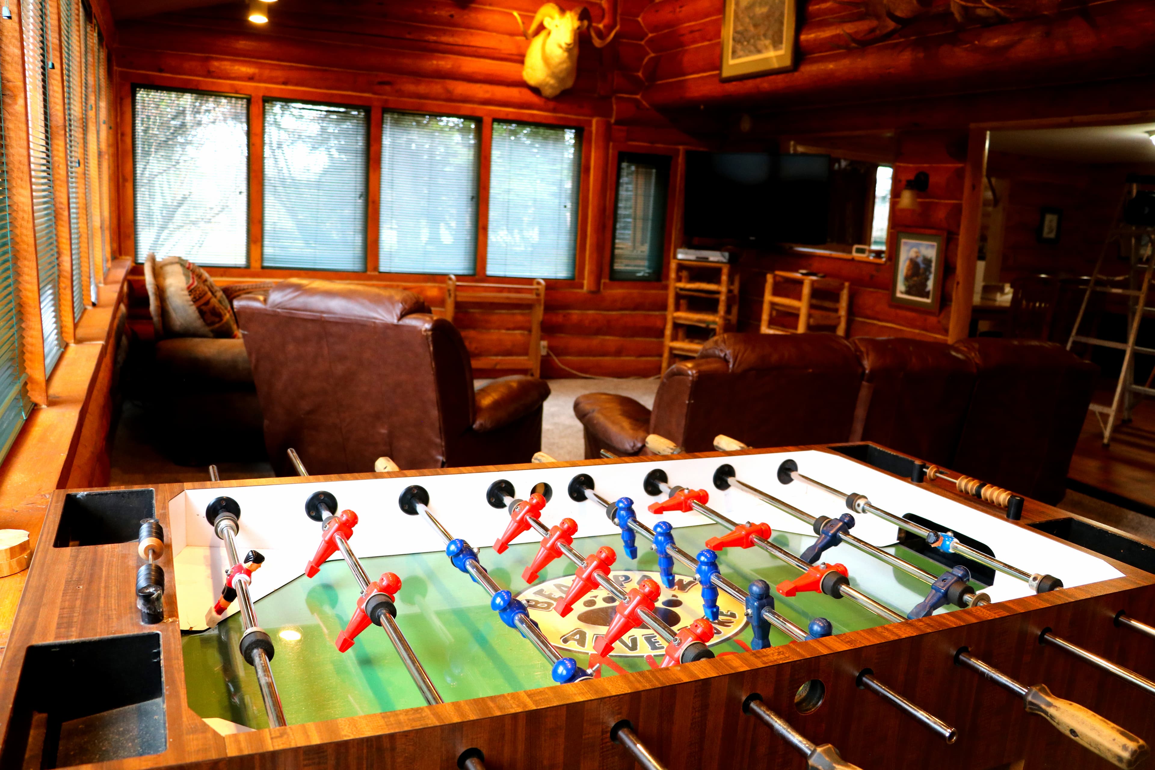 Foosball table in the foreground with cozy sitting area in the background.