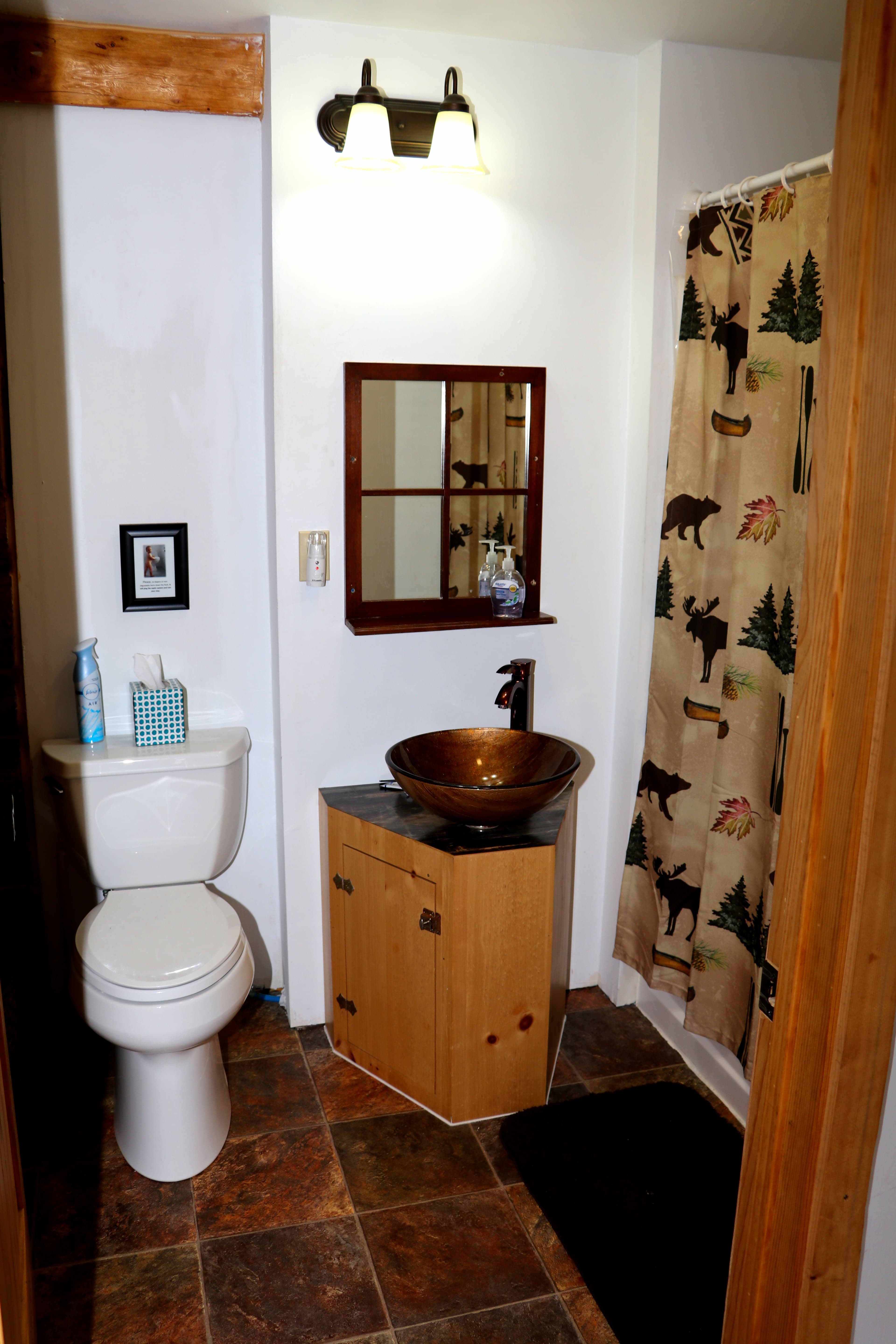 First floor bathroom with toilet, sink with vessel basin, and shower.