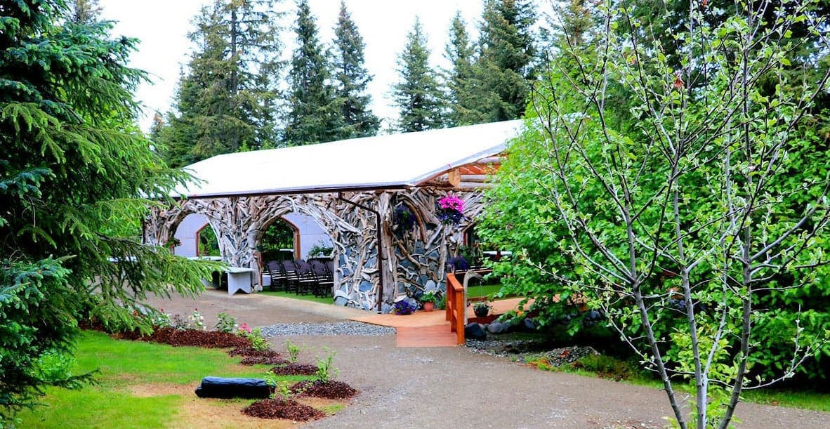 A rustic building surrounded by lush greenery and trees.
