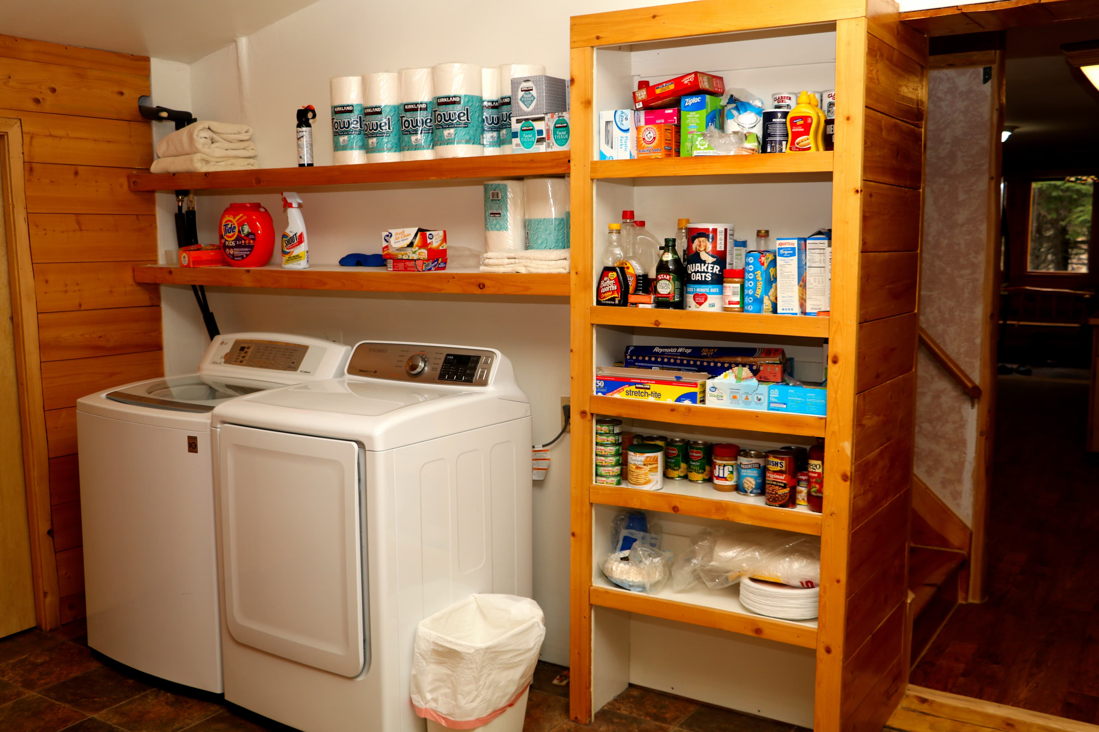 Laundry Room with washing machine and dryer and well-stocked pantry shelves.